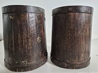 Front view of both cylindrical wood pots showing iron banding