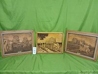 All three framed relief carvings side by side