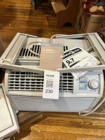 Full view of air conditioner with side panels, manual and EnergyGuide sheet visible