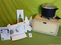 Group shot displaying breadbox, cooker, slicer, attachments and manual