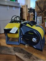 Two yellow/gray Stanley blower fans showing fronts, cords and control knobs