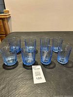 Set of eight blue ribbed Duralex tumblers on table