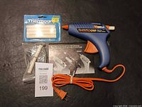 Overall contents: Thermogrip glue gun, sealed glue stick pack, loose glue stick, instruction manual