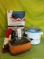 Group view of Crock-Pot, stockpot, roaster, boxed baking dish, two silicone mats