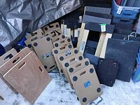 Group of MDF, carpeted and plastic dollies stacked outdoors