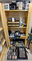 Full shelving unit with multiple cassette tapes, drawer cabinets, carrying cases