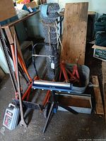 Overall view showing multiple tools including handi roller, farm jacks, chain link roll, dolly, galvanized trays