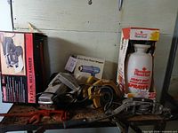 Overview of all items including boxed belt sander, pump sprayer, heat gun and loose tools