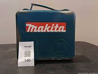 Closed teal Makita metal case with lot number card