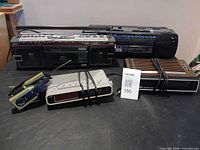 Group shot showing both boomboxes, two clock radios and headphones