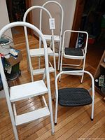 Four unfolded step stools showing step surfaces and handles