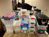 Group of assorted clear plastic totes, latch boxes and project cases stacked together