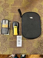 Two stud finders with zippered case on tabletop