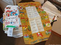 Stack of vintage linen tea towels showing 1973 calendar towel and house print towel