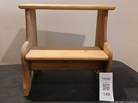 front view of small wooden step stool showing two steps and side supports