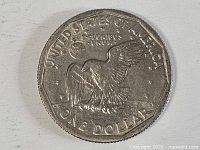 Reverse of 1979 SBA dollar showing eagle landing on moon, denomination visible