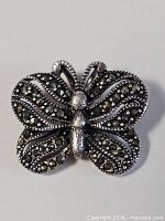 Front view of butterfly pendant with stone inlay