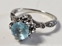Side angle of ring showing aquamarine stone and decorative shoulder