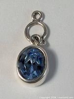 Front view of sterling silver pendant showing blue topaz cabochon