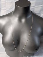 Necklace draped on bust showing full length