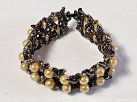 Bracelet shown in circular form highlighting pearls and metal links