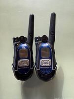 Front view of both Motorola blue/black walkie talkies showing displays, keypads and antennas