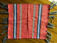 Full view of red wool runner with striped design and fringe