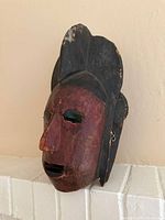 Front/side view showing red face, black crest, eye and mouth openings