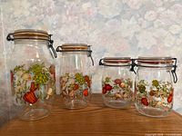 four graduated Spice of Life glass canisters on shelf