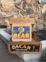 All three stacked crates showing Knott's branding, Bear paper label and Oscar grape crate