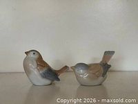 Front view of both porcelain sparrow figurines