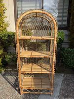 Full front view of arched bamboo bookcase showing five shelves