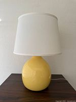 Front view of yellow ceramic lamp and white shade