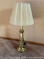 Full view of brass table lamp with shade