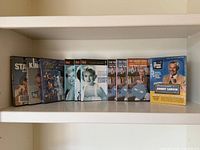 Wide shot showing entire row of eleven DVD cases on shelf