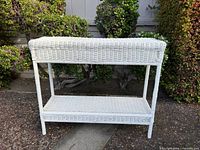 Front view of white wicker console table showing full structure