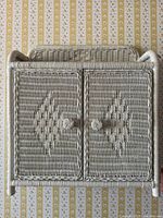 front view of white wicker cabinet with doors closed