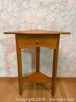 Full view of wooden corner table showing drawer and lower shelf