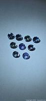Nine round Tanzanite stones on neutral background
