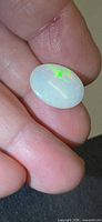 Opal held between fingers showing green flash