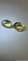 Pair of oval faceted lemon citrines on neutral background