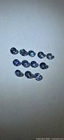 All 12 round blue sapphires arranged on neutral background