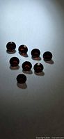Group of eight round red garnets on neutral background