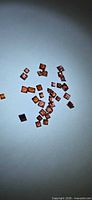 Loose square-cut orange-red garnets scattered on background