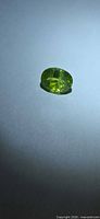 Front view of oval peridot showing apple-green color