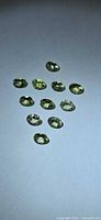 11 faceted oval yellow-green stones arranged in diamond pattern