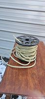 Full view of rope lighting wound on black plastic spool