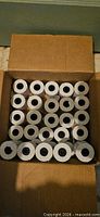 Open box showing 30 white thermal receipt paper rolls stacked upright