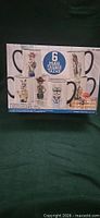 Front of boxed set showing six animal graphic mugs