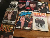 Group shot of all eight Beatles and Lennon publications